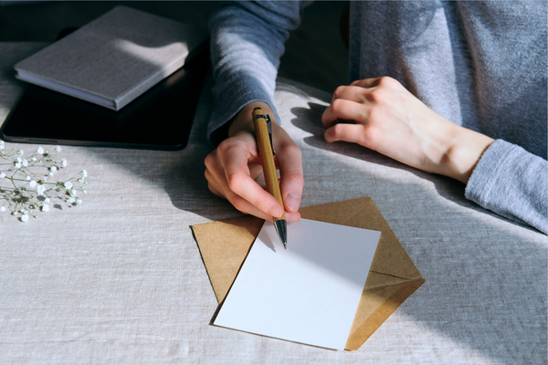 Bilde av hender som skriver et brev 